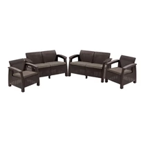 Nehéz műrattan kerti bútor szett, amely két kétszemélyes kanapéból és két fotelból áll, világos szürke párnákkal. Elegáns, barna színben, fehér háttér előtt kiemelve, kültéri használatra tervezve.